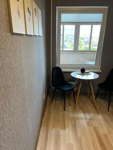 een kamer met een tafel en stoelen en een raam bij Zemgales ielas apartamenti in Jēkabpils