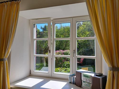 a room with two large windows and a desk at Ferienwohnungen im Lüftlmalereck, Mussldomahaus in Oberammergau