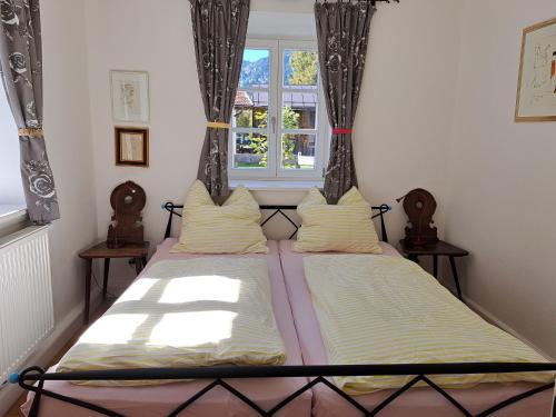 two beds in a room with a window at Ferienwohnungen im Lüftlmalereck, Mussldomahaus in Oberammergau
