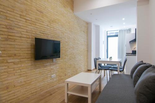 sala de estar con TV en una pared de ladrillo en VLC Host - Gulliver Riverside en Valencia