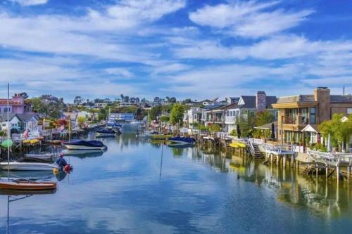 a river with boats docked in a town at Newport Beach Living (1 blk to beach and 25 min to Disney) in Newport Beach