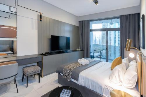 a hotel room with a bed and a television at Lux Studio in Downtown, 5 mins to Burj Khalifa & Dubai Mall - MAG318 in Dubai