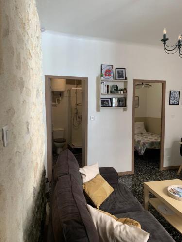sala de estar con sofá y espejo en Appartement au coeur du quartier de la Roquette, en Arles