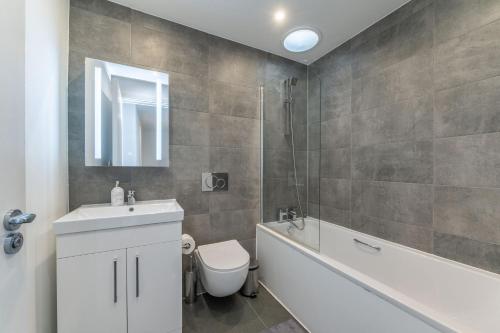 a bathroom with a sink and a toilet and a bath tub at Luxury 2 Bed 2 Bath London Home - Vauxhall, Battersea & Nine Elms in London