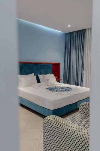 a bedroom with a bed and a chair at Hotel Divo Palace in Ksamil