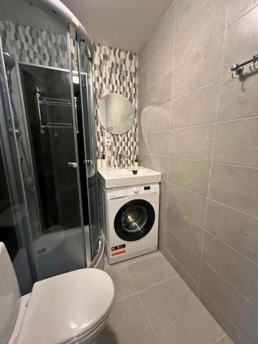a bathroom with a toilet and a washing machine at Zemgales ielas apartamenti in Jēkabpils