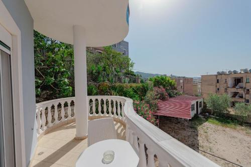 a balcony with a white table and a view of a city at Hotel Divo Palace in Ksamil