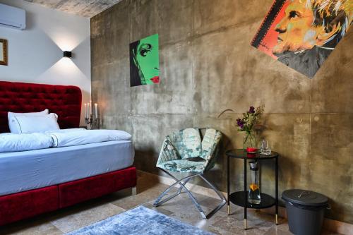 普若佛的住宿－Cittadella Suite，一间卧室配有红色的床和椅子