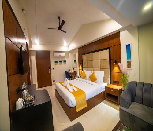 una camera d'albergo con letto e divano di HUE GUH The Porto Candolim a Calangute