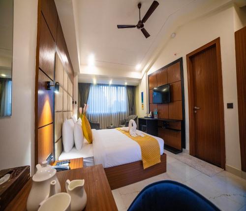 a hotel room with a large bed and a table at HUE GUH The Porto Candolim in Calangute
