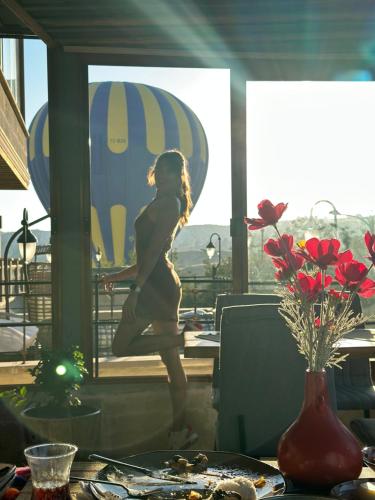 a woman walking in a room with a table at Aysel Inn House in Goreme