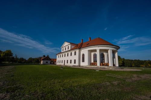 un gran edificio blanco con techo rojo en un campo en Zámeček - Chateau Lány, en Břeclav