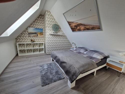 ein Schlafzimmer mit einem Bett in einem Zimmer mit einer Treppe in der Unterkunft Ferienwohnung Lerchi's Ankerplatz in Barßel