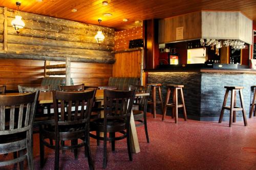 a restaurant with wooden walls and chairs and a bar at Ivalo River Camping in Ivalo