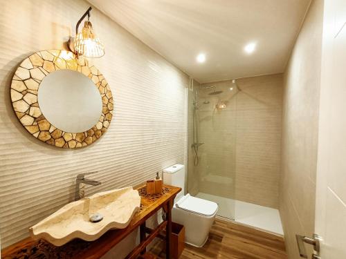 a bathroom with a sink and a shower and a mirror at Chakra House Fuerteventura in Corralejo
