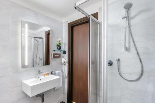 ein Bad mit einem Waschbecken und einer Dusche in der Unterkunft Hotel King, by R Collection Hotels in Varedo