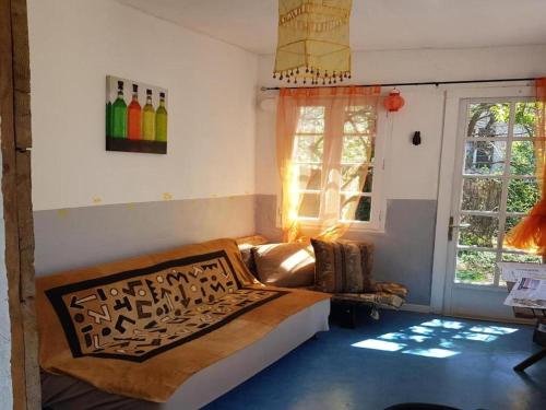 ReillanneにあるLes Marronniers du Luberonのベッド1台、ソファ、窓が備わる客室です。