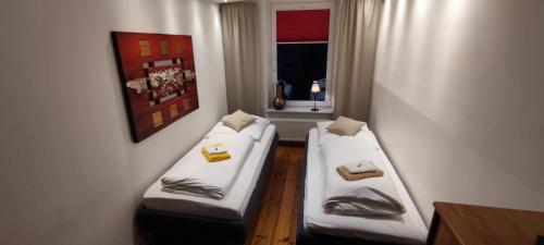 two beds in a small room with a window at Zum Fuchsbau - Schöneiche bei Berlin in Schöneiche