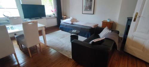 a living room with two couches and a table at Zum Fuchsbau - Schöneiche bei Berlin in Schöneiche