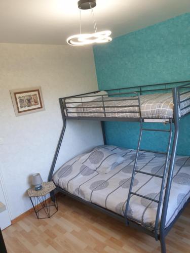 une chambre avec deux lits superposés dans une pièce dans l'établissement Jolie maison de vacances, à Gagnac-sur-Cère