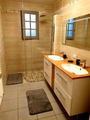 une salle de bain avec deux lavabos et une douche dans l'établissement Jolie maison de vacances, à Gagnac-sur-Cère