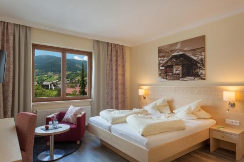 um quarto de hotel com uma cama e uma janela em Family & Sporthotel Kärntnerhof em Bad Kleinkirchheim