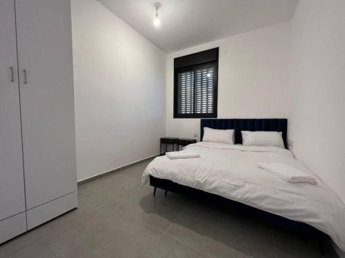 a white bedroom with a large bed and a window at Menahem Arber 5 Bedrooms in Tel Aviv