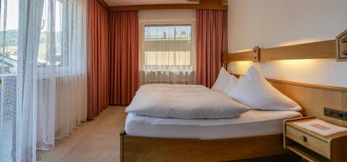 a bedroom with a bed and a large window at Landhaus Haid in Seefeld in Tirol