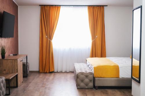 a bedroom with a bed and a large window at Hotel Domestika in Skopje