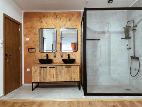 uma casa de banho com 2 lavatórios e um chuveiro em Hotel Restaurant Domestika em Skopje
