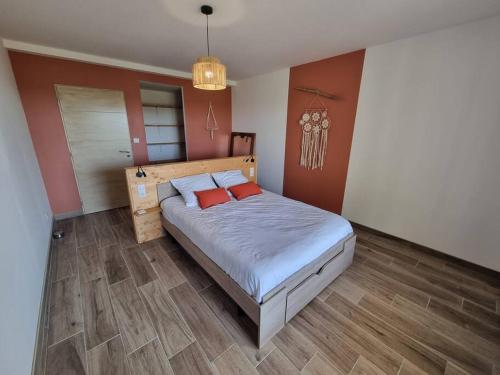 a bedroom with a bed with two red pillows at Gîte de Lamothe in Pimbo