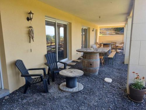 eine Terrasse mit einem Tisch und Stühlen sowie einem Tisch und Stühlen in der Unterkunft Gîte de Lamothe in Pimbo