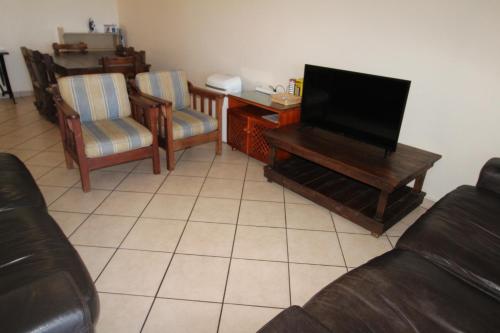 a living room with a couch and a flat screen tv at Strandloper 3 in Margate
