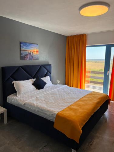 - une chambre avec un grand lit et une grande fenêtre dans l'établissement Delta View, à Dunavăţu de Jos