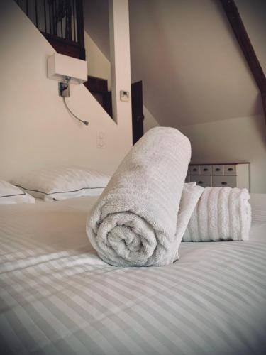 a stack of towels sitting on top of a bed at Le Moulin du Château de Horgues in Horgues