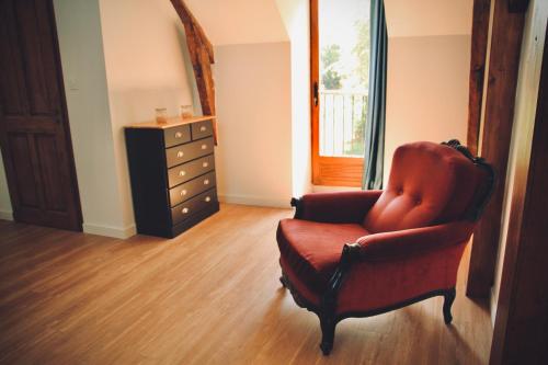 a living room with a chair and a dresser at Le Moulin du Château de Horgues in Horgues