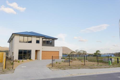 a house with a fence in front of a street at Hobart Luxury Waterfront Retreat 4BR Award-Winning Stay in Hobart