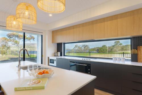 a kitchen with a sink and a large window at Hobart Luxury Waterfront Retreat 4BR Award-Winning Stay in Hobart