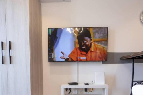 a tv hanging on a wall in a living room at The Lennox Studio @Airport Residential in Accra