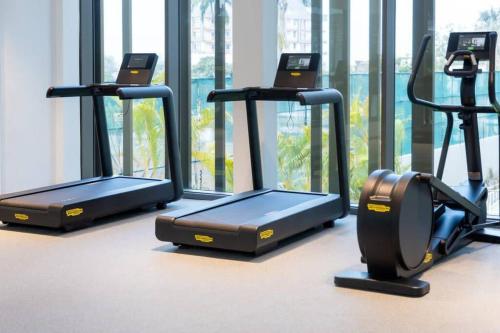 a row of treadmills in a gym with windows at The Lennox Studio @Airport Residential in Accra