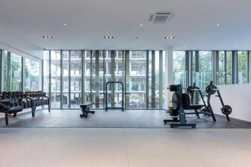 a gym with treadmills and machines in a room with windows at The Lennox Studio @Airport Residential in Accra
