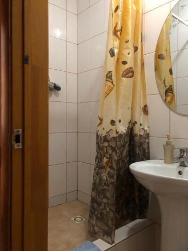 a bathroom with a shower curtain next to a sink at Apartment complex in Sumy