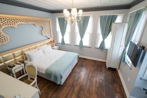 a bedroom with a large bed and a chandelier at Best Pasaport Pier Otel Kadıköy in Istanbul