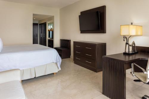 a bedroom with a bed and a desk and a television at Intercontinental Miramar Panama by IHG in Panama City