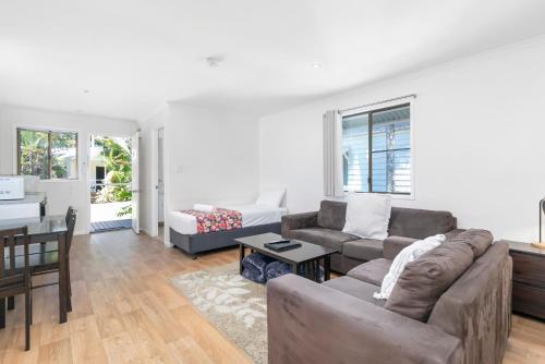 a living room with a couch and a table at Mossman Resort Holiday Villas in Mossman