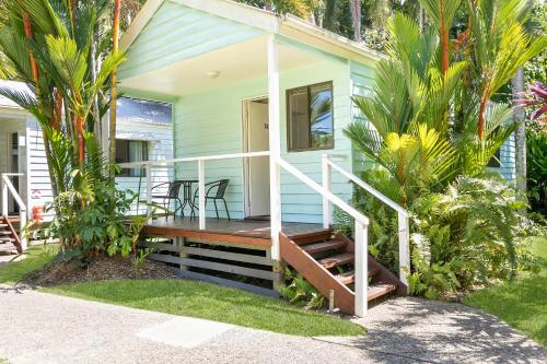 a tiny house with a porch and a deck at Mossman Resort Holiday Villas in Mossman