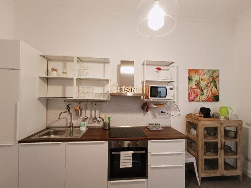 eine kleine Küche mit weißen Schränken und einem Waschbecken in der Unterkunft La tua casa a Piazza del Popolo in Rom