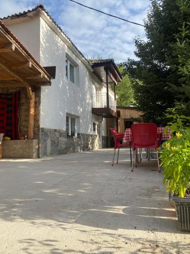 a group of red chairs sitting outside of a house at Guest House BOZVILL in Bozovec