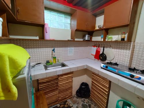 a small kitchen with a sink and a stove at Yuki Lodge - El Nido PH in El Nido