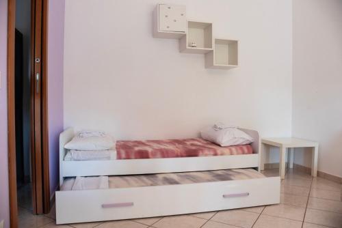 um pequeno quarto com uma cama e uma mesa em Red House Tiburtina em Roma